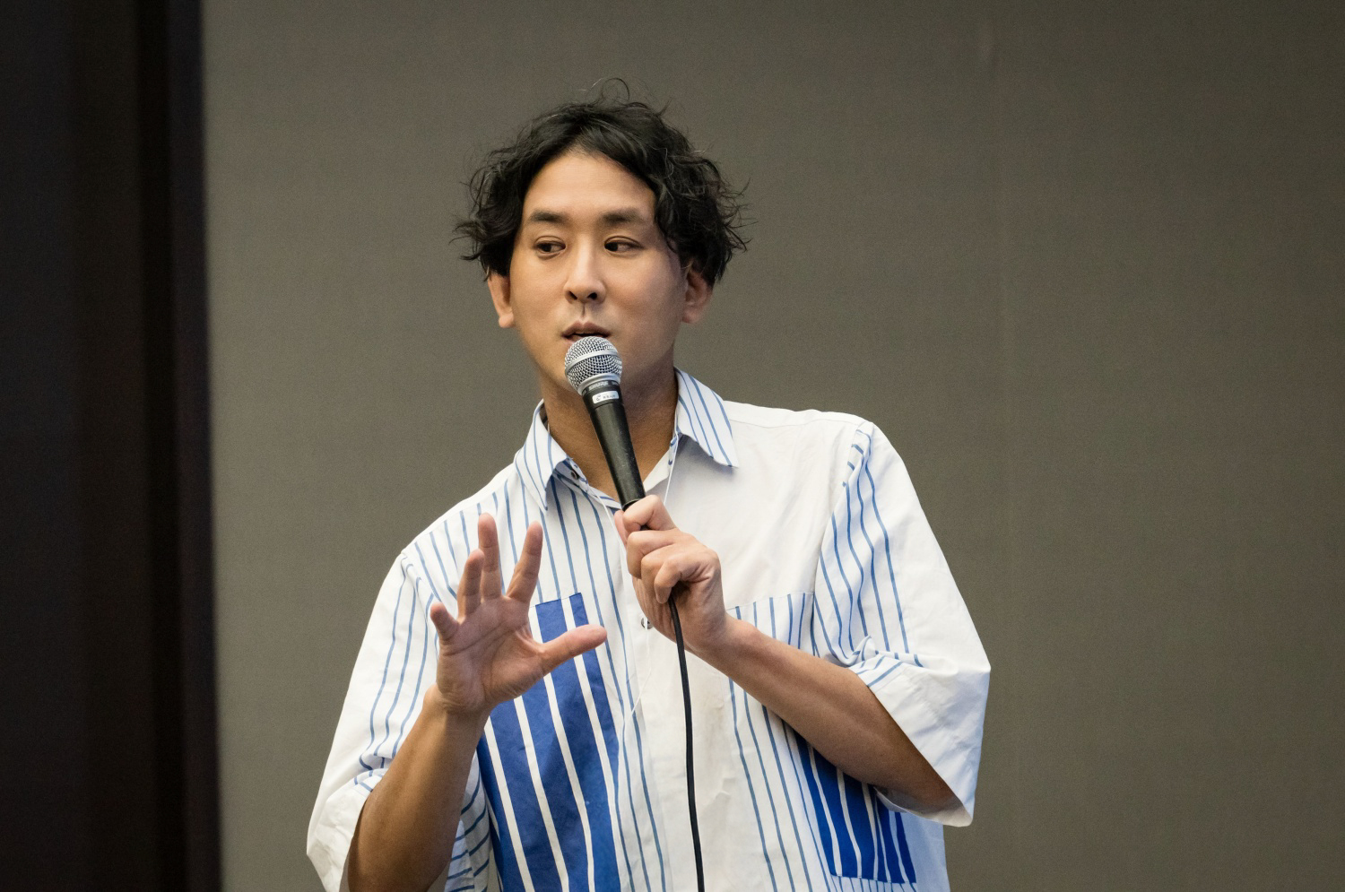 マイクを手に、身振りを交えて語る堀内恭隆