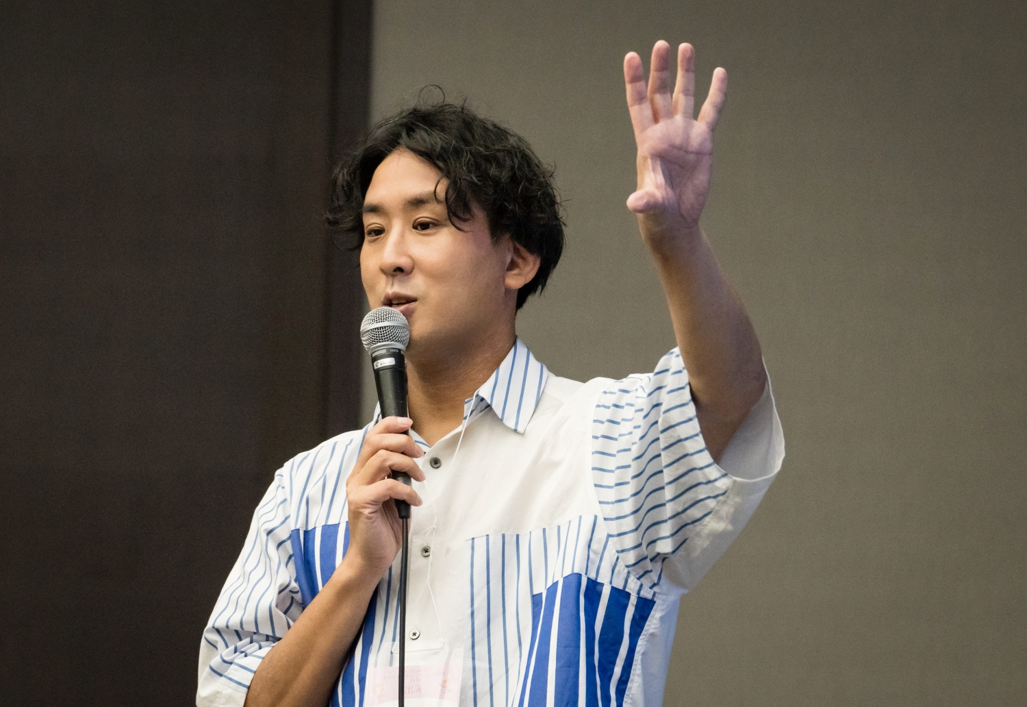 手を上げ、参加者に語りかける堀内恭隆